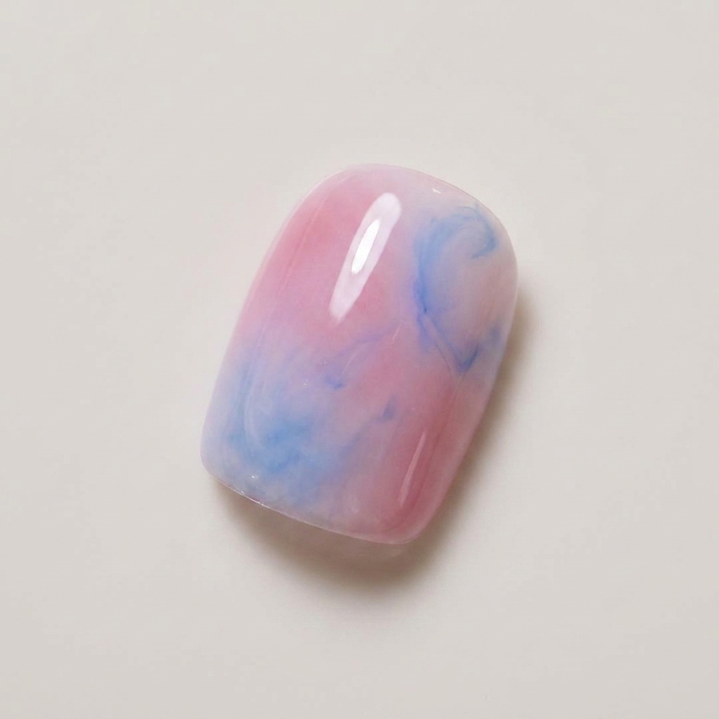 Un ongle présentant un mélange estompé de gel rose nude et bleu clair.