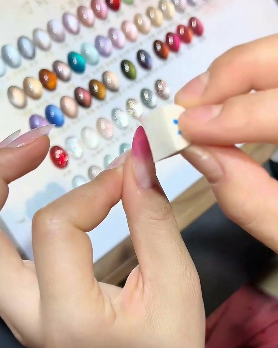 Gros plan dun bout déponge imbibé de vernis gel magenta.