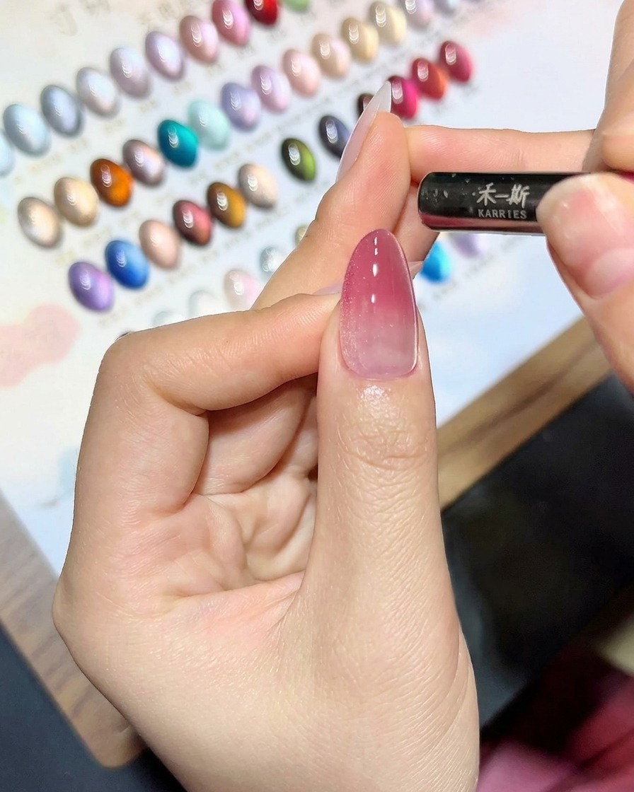 Un outil magnétique tenu près dun ongle recouvert de gel œil de chat pour créer une ligne de reflets.