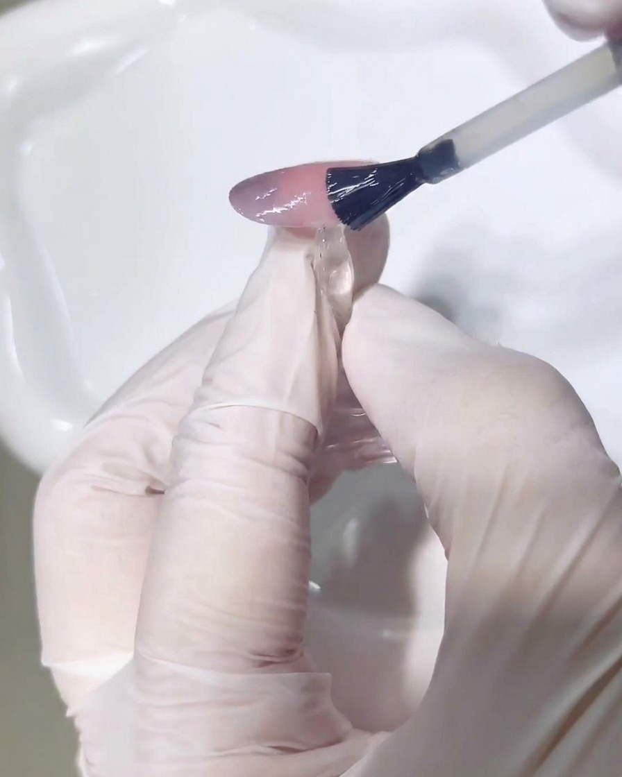 Application dun top coat brillant sur le nail art terminé.