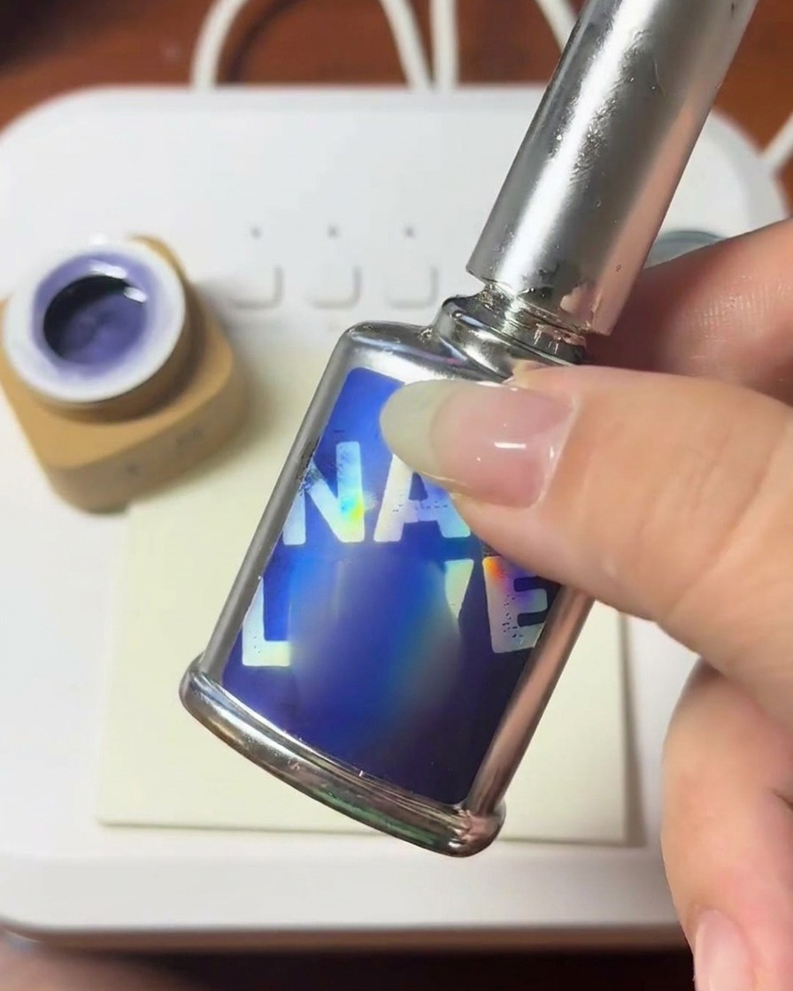 Un pinceau appliquant une goutte de gel de construction clair sur la surface dun ongle.