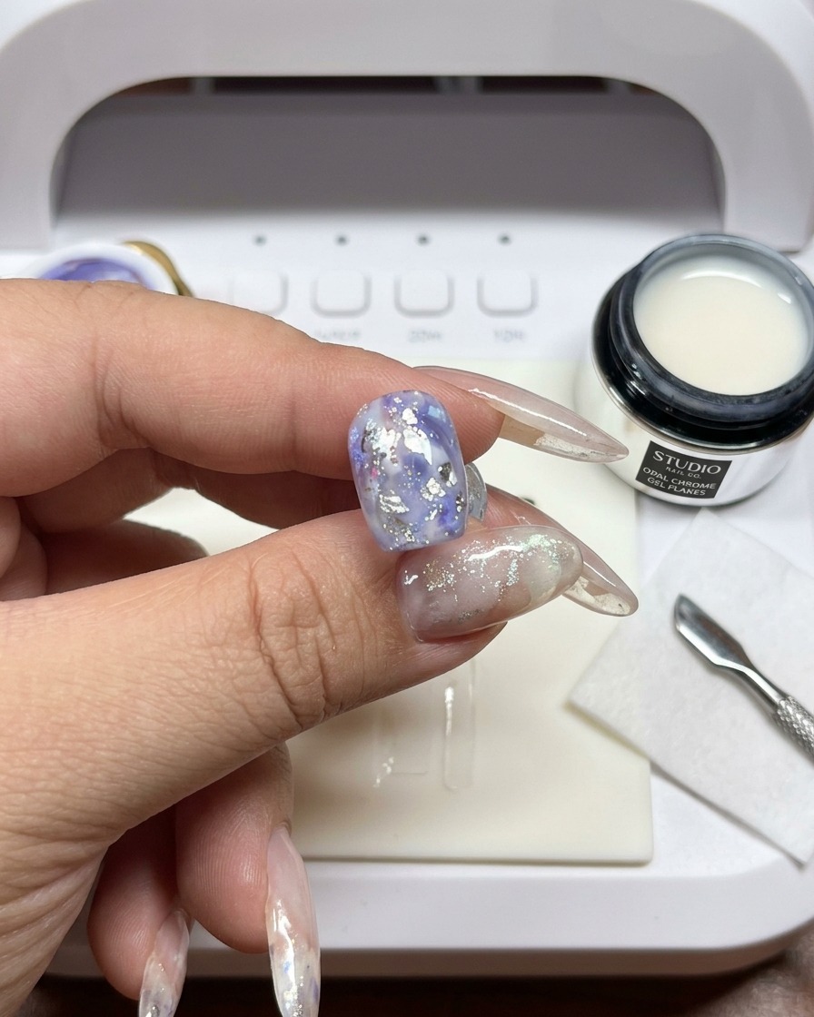 Un pinceau utilisé pour mélanger et flouter les bords du gel blanc sur longle.