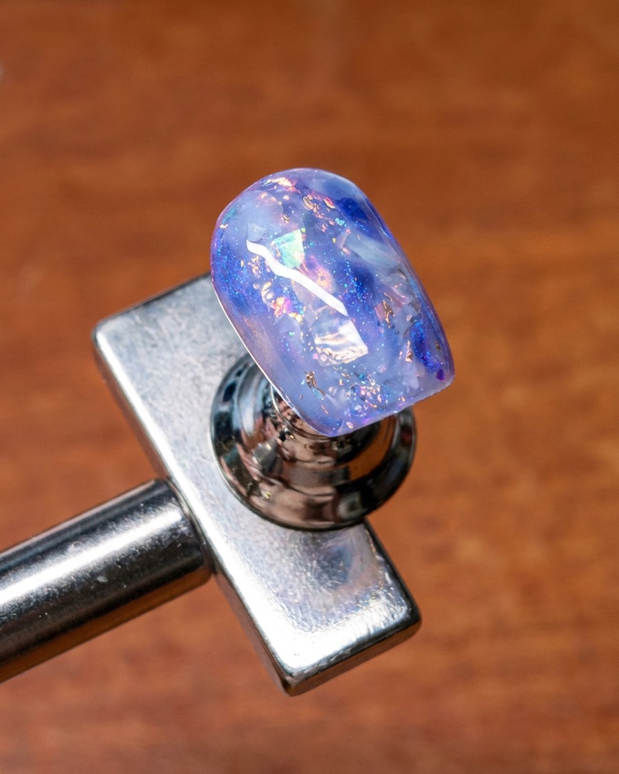 Un pinceau utilisé pour mélanger du gel de base sur les bords des coquillages et paillettes incrustés pour un look doux et diffus.