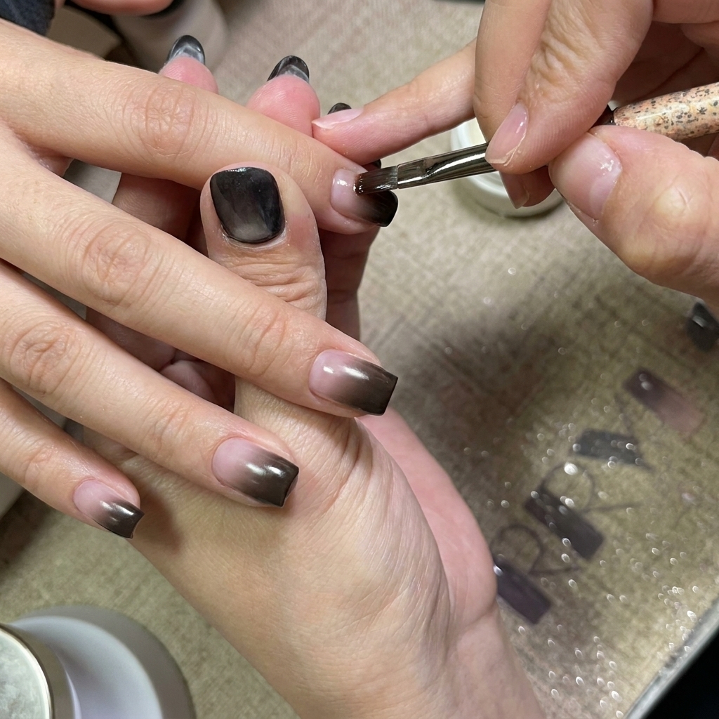 Application dune couche de gel transparent sur les ongles en dégradé.