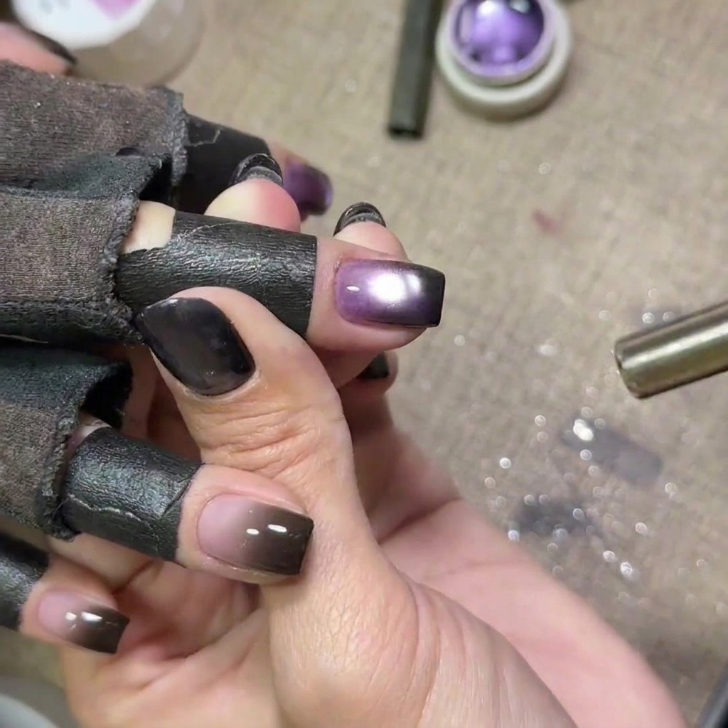 Ongles en gel violet sous une lampe UV.