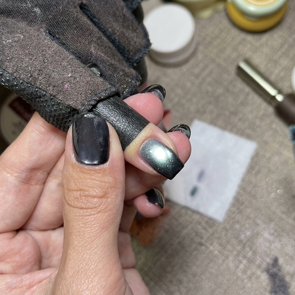 Ongles bleu cat eye en cours de catalyse sous une lampe.