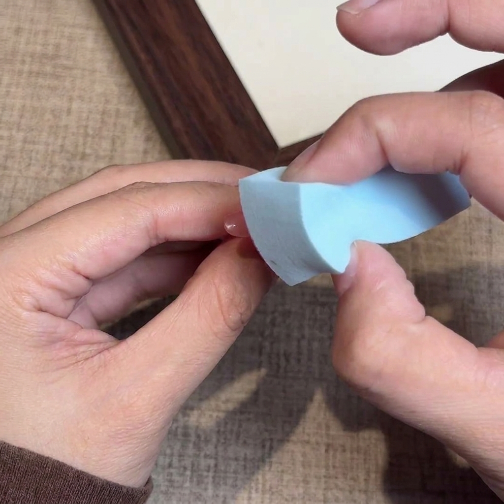 Vue rapprochée dune éponge appliquant du vernis gel sur le bout de longle.