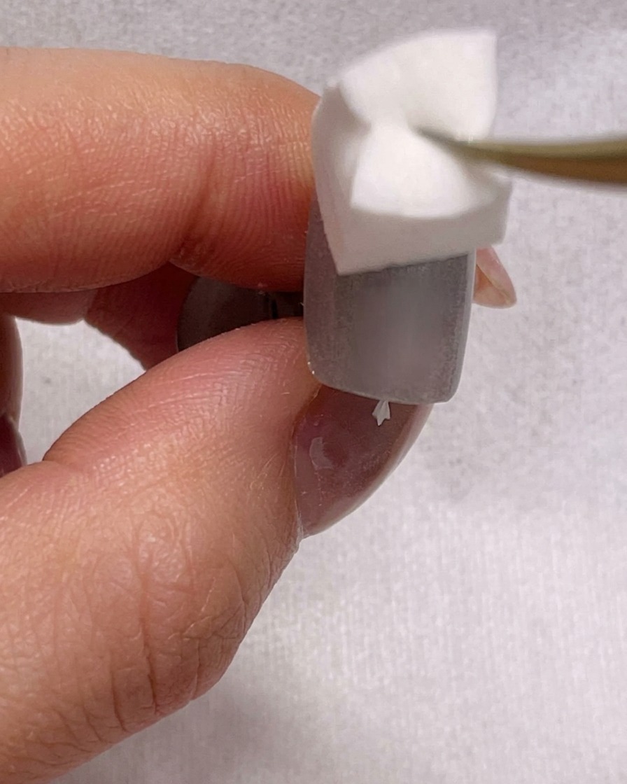 Vue rapprochée dune éponge estompant du vernis bleu sur un ongle pour créer un effet ombré.