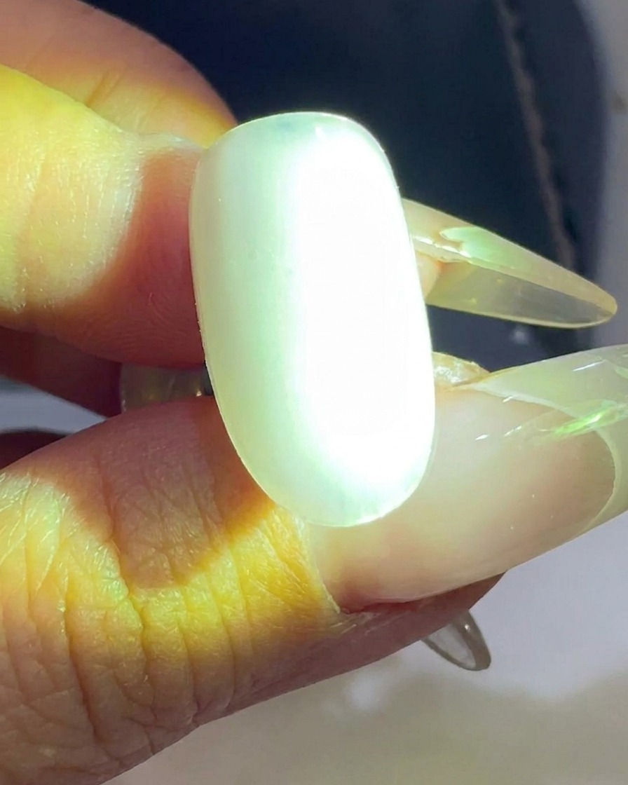 Un tips dongle transparent en cours de catalysation sous une lampe à ongles UV/LED.