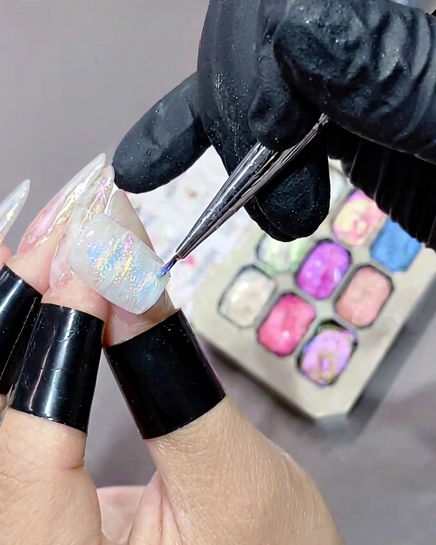 Un ongle avec un motif en gel marbré et texturé tout juste appliqué en train dêtre placé dans une lampe UV.