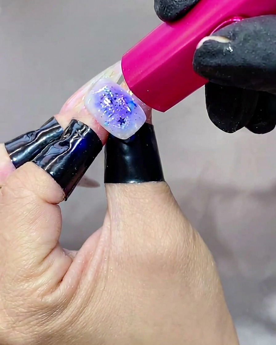 Une main sous une lampe UV lumineuse, catalysant lultime couche de top coat.