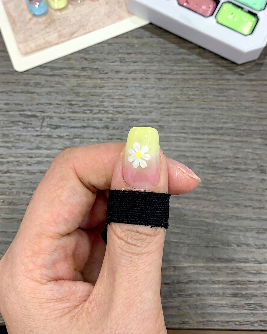 Gros plan dun ongle avec une couche épaisse de vernis gel jaune appliquée sur le bord libre à laide dun pinceau carré.