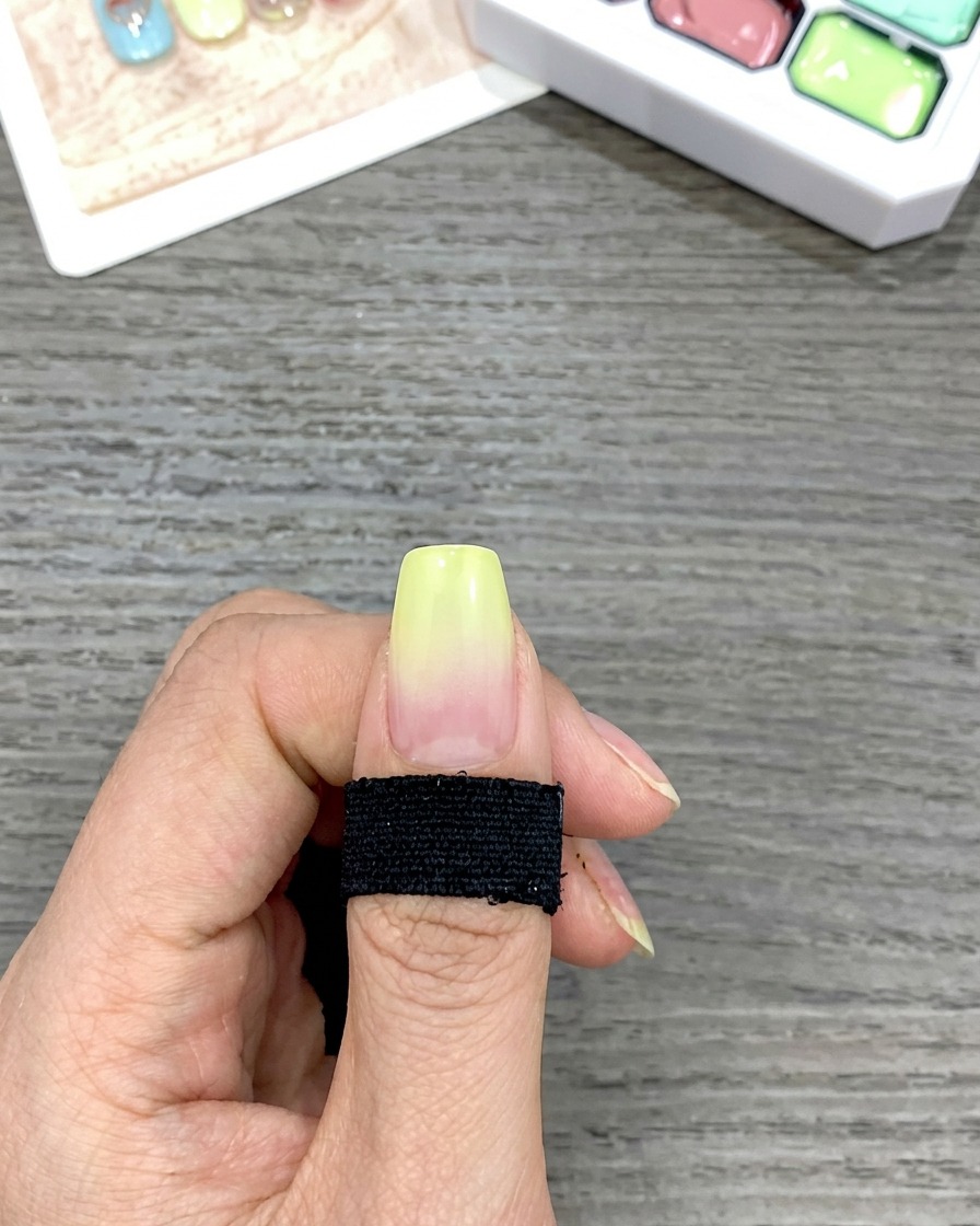 Gros plan montrant un dégradé fluide du jaune vers le naturel sur un ongle, créé en tapotant avec une éponge.