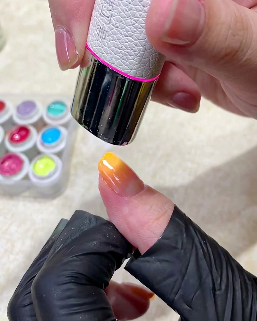 Un doigt manucuré placé sous une lampe UV professionnelle pour catalyser lapplication du vernis gel.