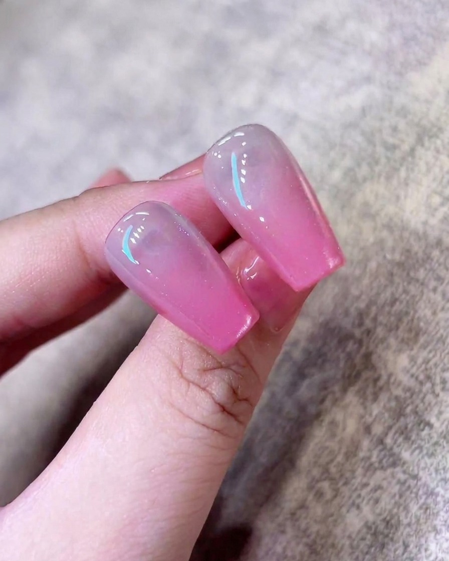 Une dernière couche de vernis cat-eye scintillant appliquée sur longle pour parfaire la finition.