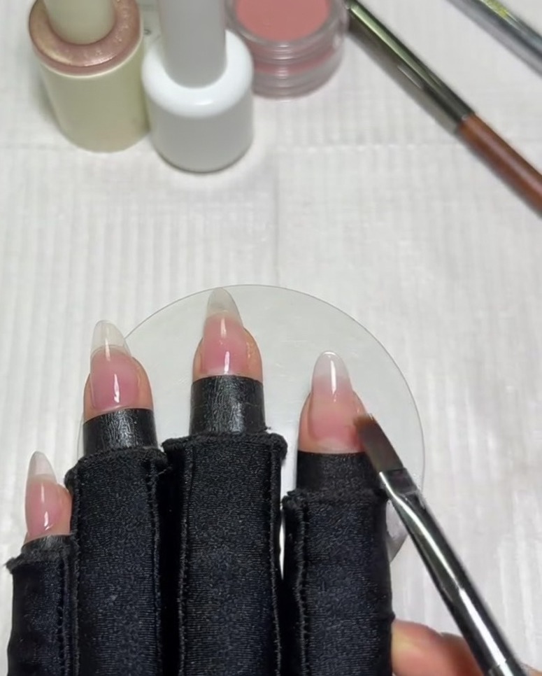 Un pinceau dégradé plat balayant horizontalement longle pour mélanger le bord du vernis gel blanc dans la base nude.