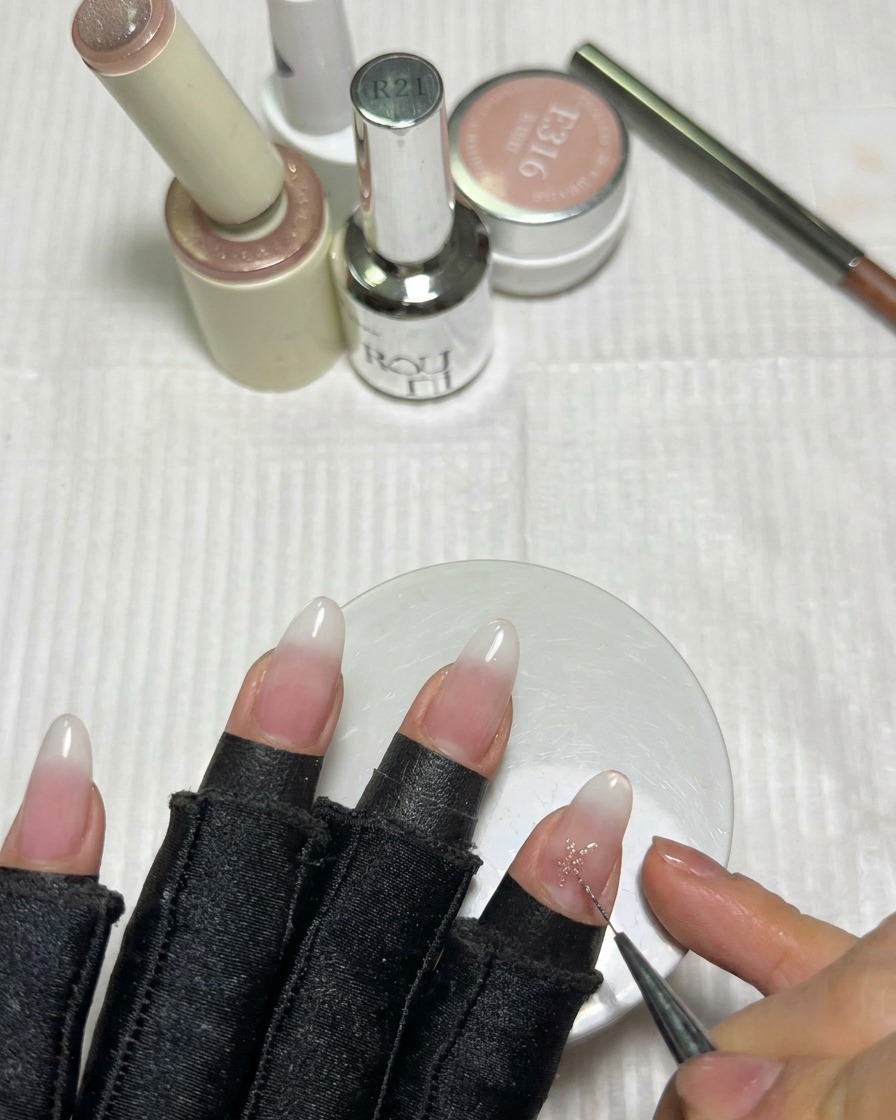 Un pinceau liner fin remplissant le centre dune étoile en gel rose pour créer des pointes acérées.