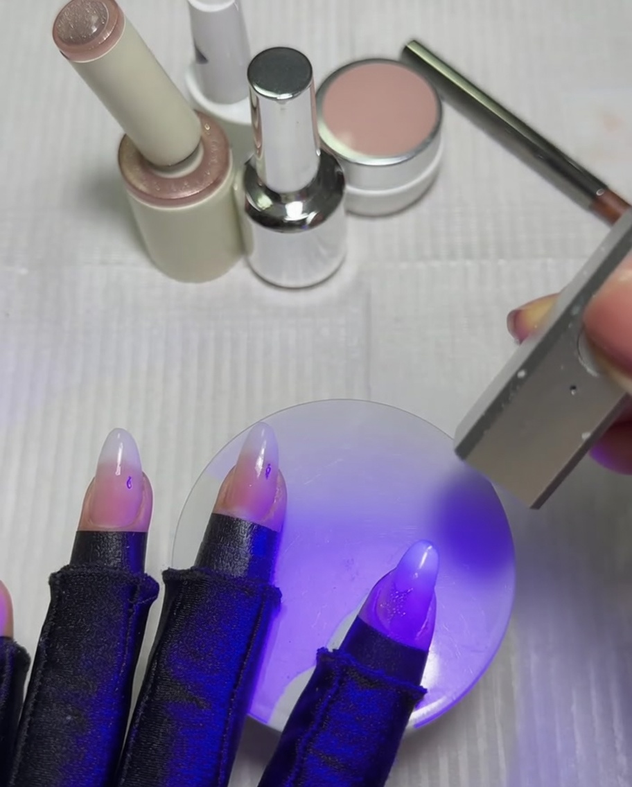 Des ongles reposant sous une lampe UV et LED pour catalyser létoile cat-eye fraîchement activée.