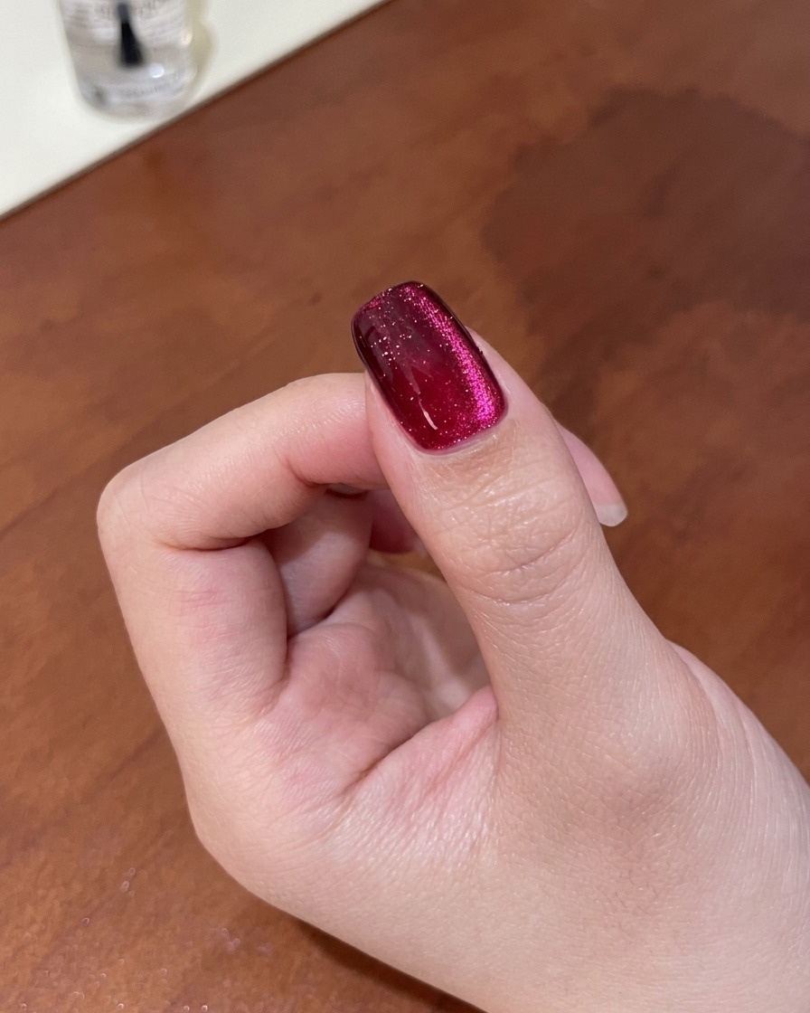 Gros plan dun ongle montrant le reflet magnétique affiné en un dégradé œil de chat profond à laide dun aimant.