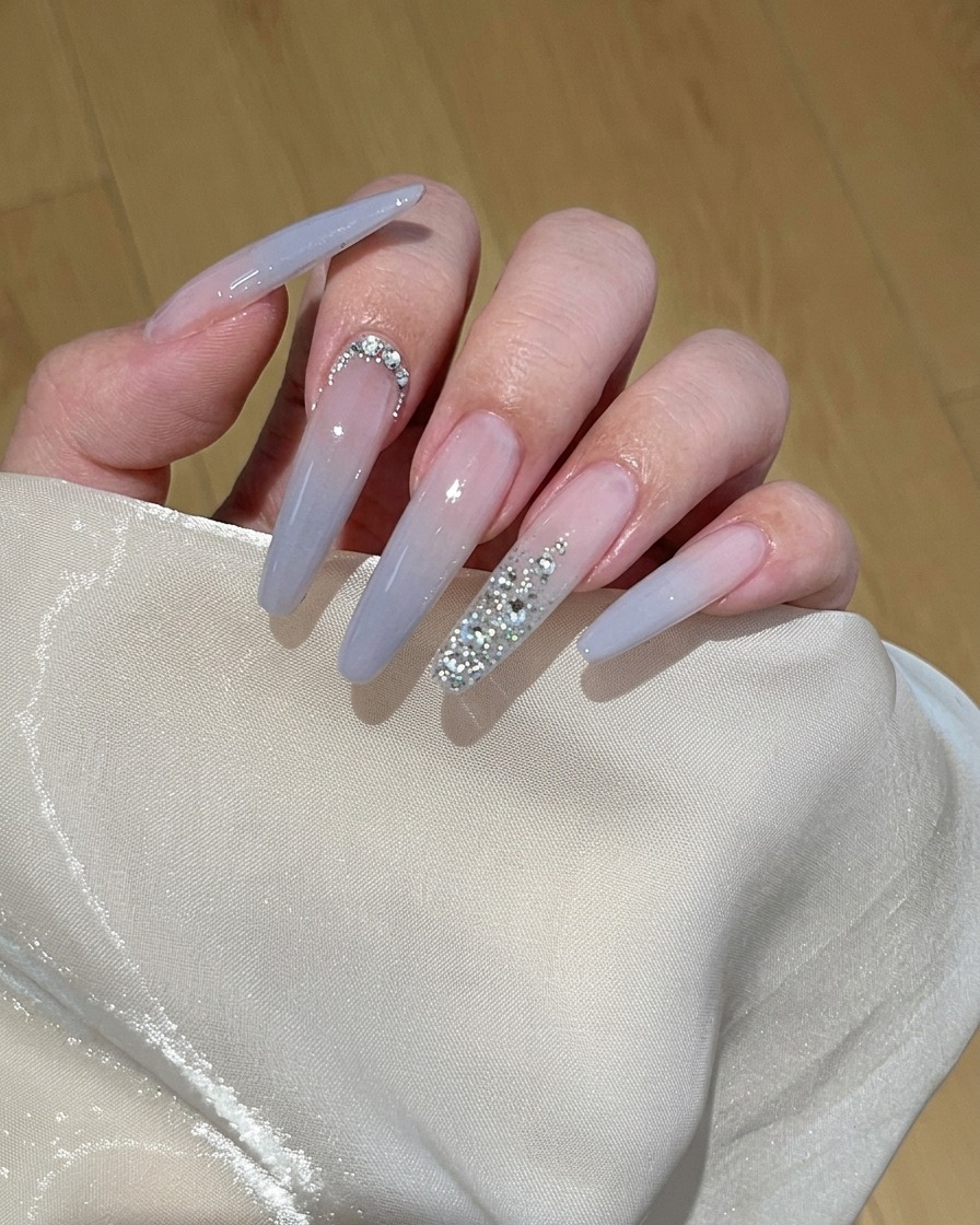 Gros plan dun pinceau appliquant un vernis gel pêche clair sur un ongle naturel.