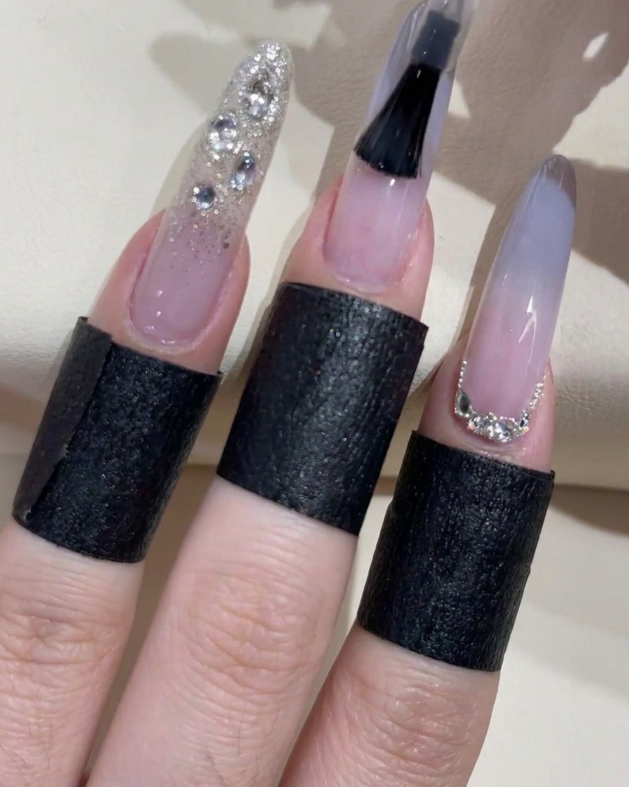 Gros plan dun pinceau appliquant un top coat transparent sur un ongle ombré bleu clair.