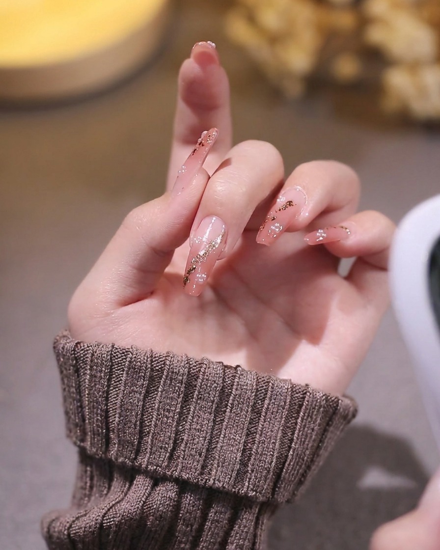 Vue rapprochée dune main aux ongles décorés placée dans une lampe UV/LED, avec la lumière éclairant les ongles.