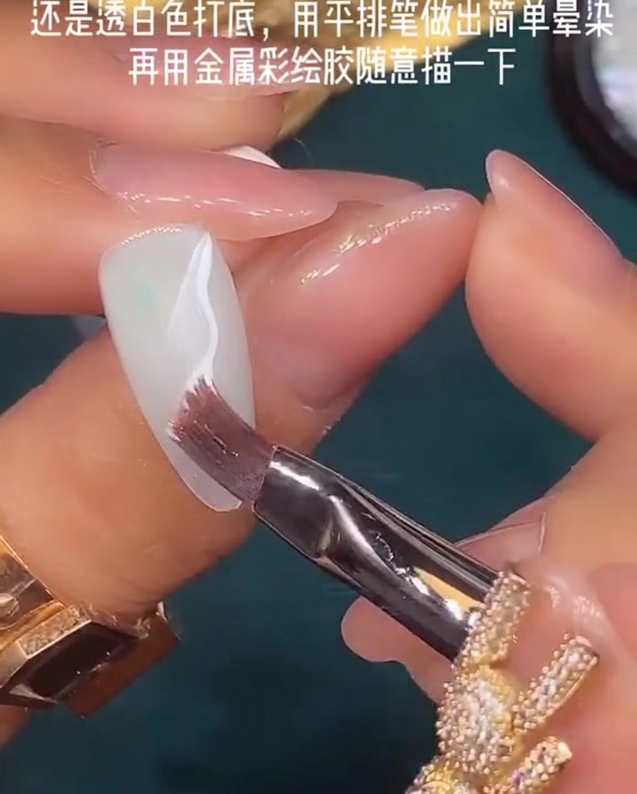 Un pinceau plat utilisé pour fondre du vernis gel blanc humide sur la surface de longle.