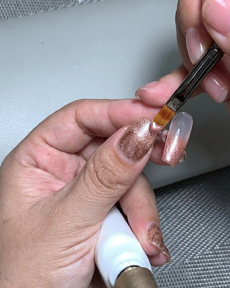 Une main placée sous une lampe UV pour catalyser la couche de gel de structure.