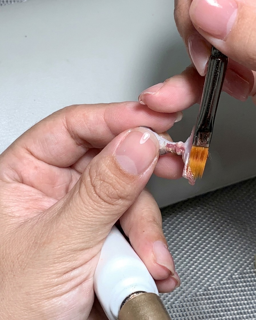 Une lime à ongles utilisée pour polir la surface de longle catalysé jusquà ce quelle soit lisse et uniforme.