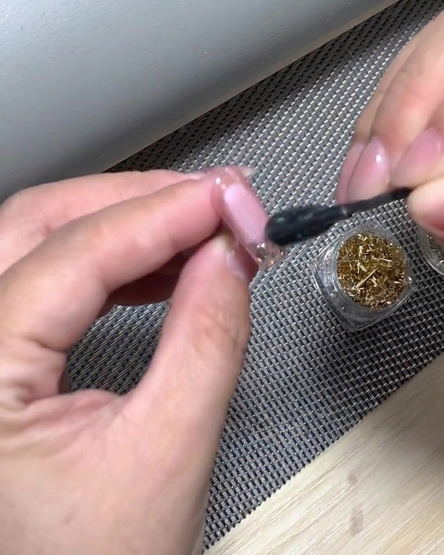 Une main positionnée dans une lampe UV pour catalyser le dégradé blanc fraîchement appliqué.
