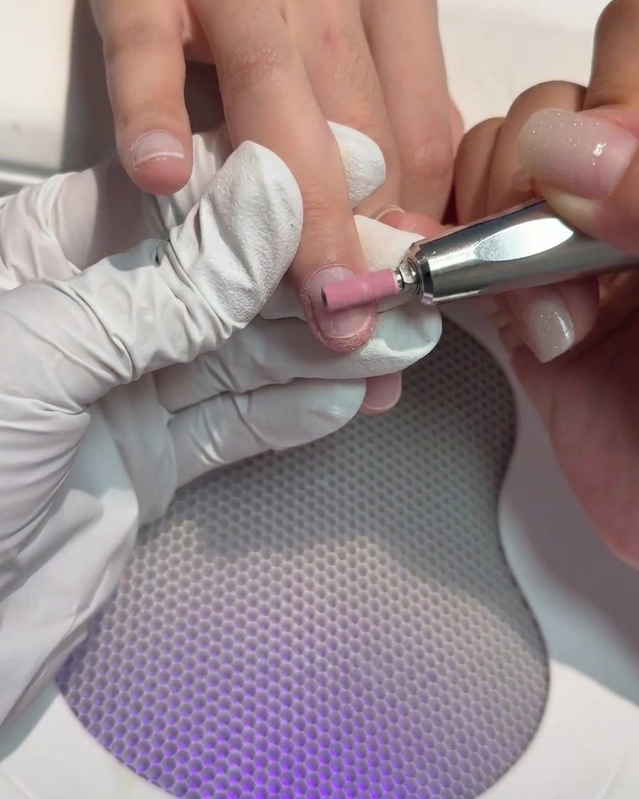 Un embout de ponceuse cylindrique utilisé pour polir la surface dun ongle naturel.