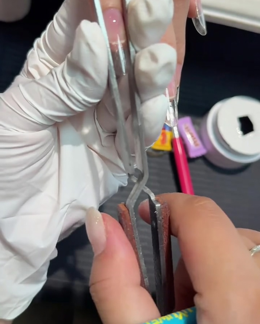 Une pince à pincer utilisée pour affiner et galber une extension en gel.