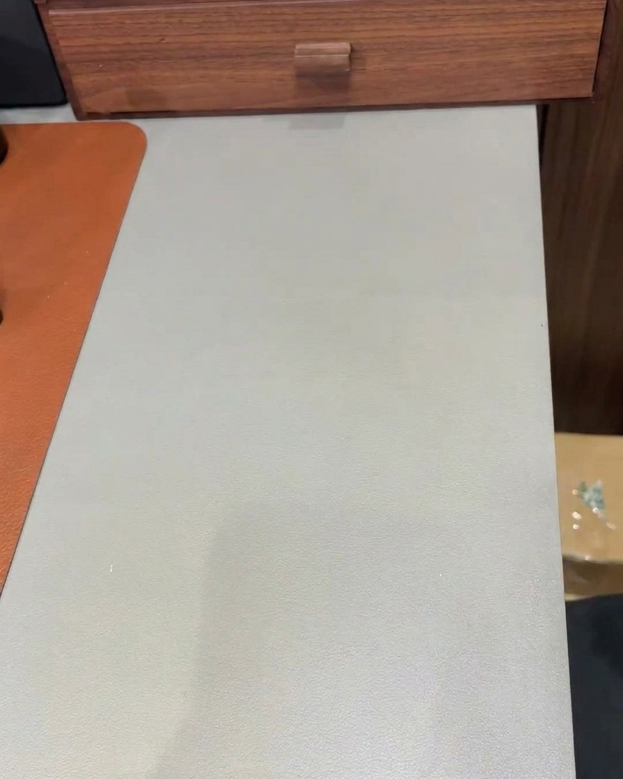 Un pinceau appliquant une couche claire de gel de construction sur un ongle recouvert de paillettes pour créer une finition lisse.