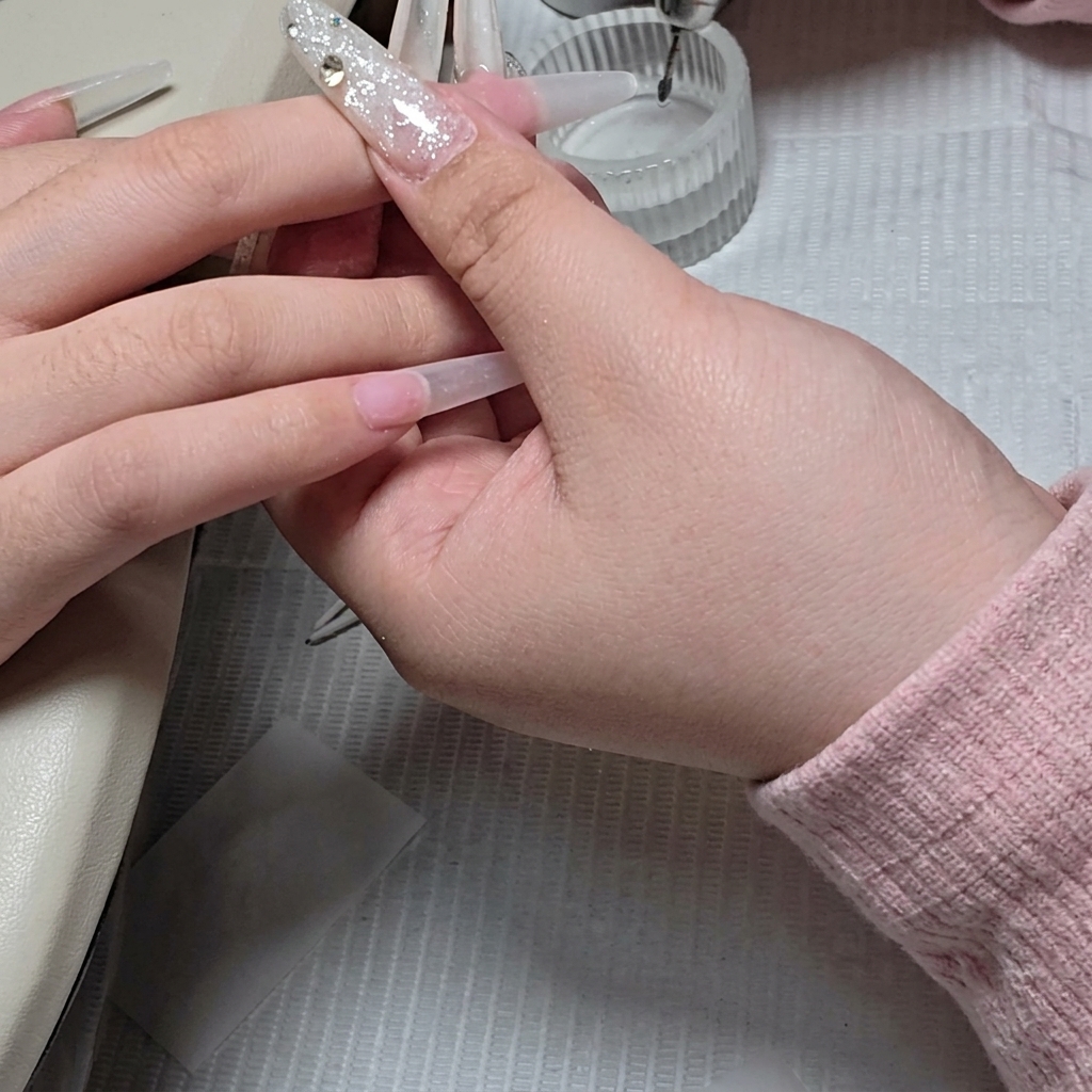 Gros plan montrant un embout de ponceuse en forme de bille utilisé pour nettoyer précisément la zone des cuticules.