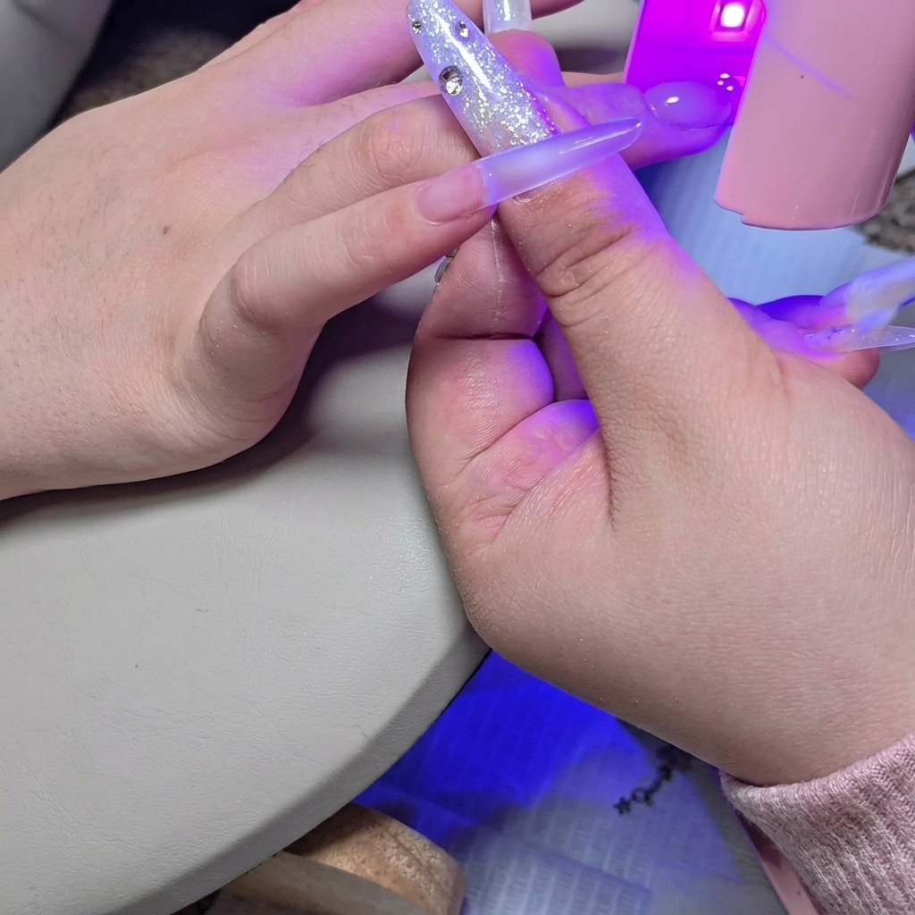 Une mini lampe UV/LED placée au-dessus de longle pour catalyser la seconde couche.