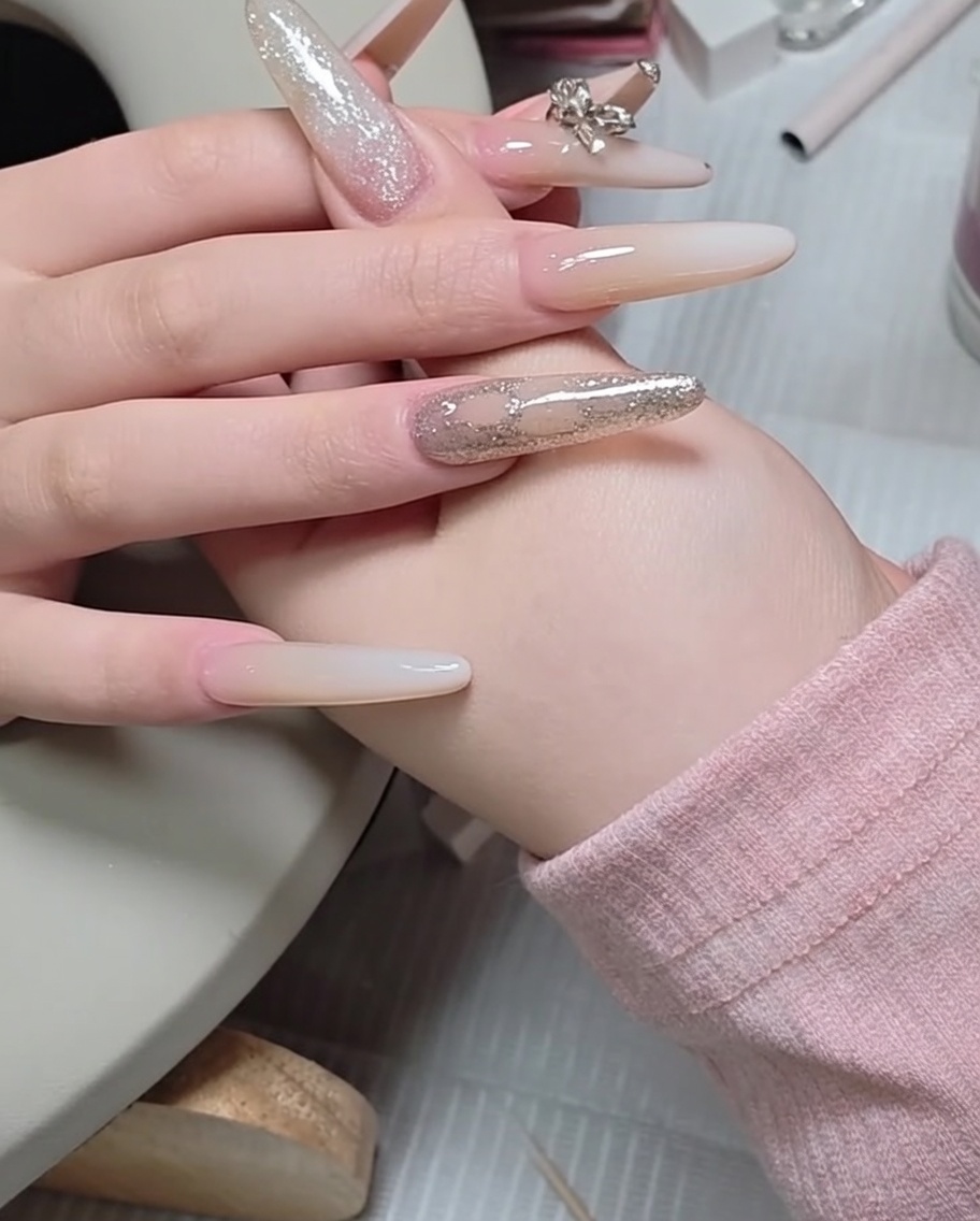 Un pousse-cuticules en métal utilisé pour ajuster un petit strass sur la surface dun ongle.