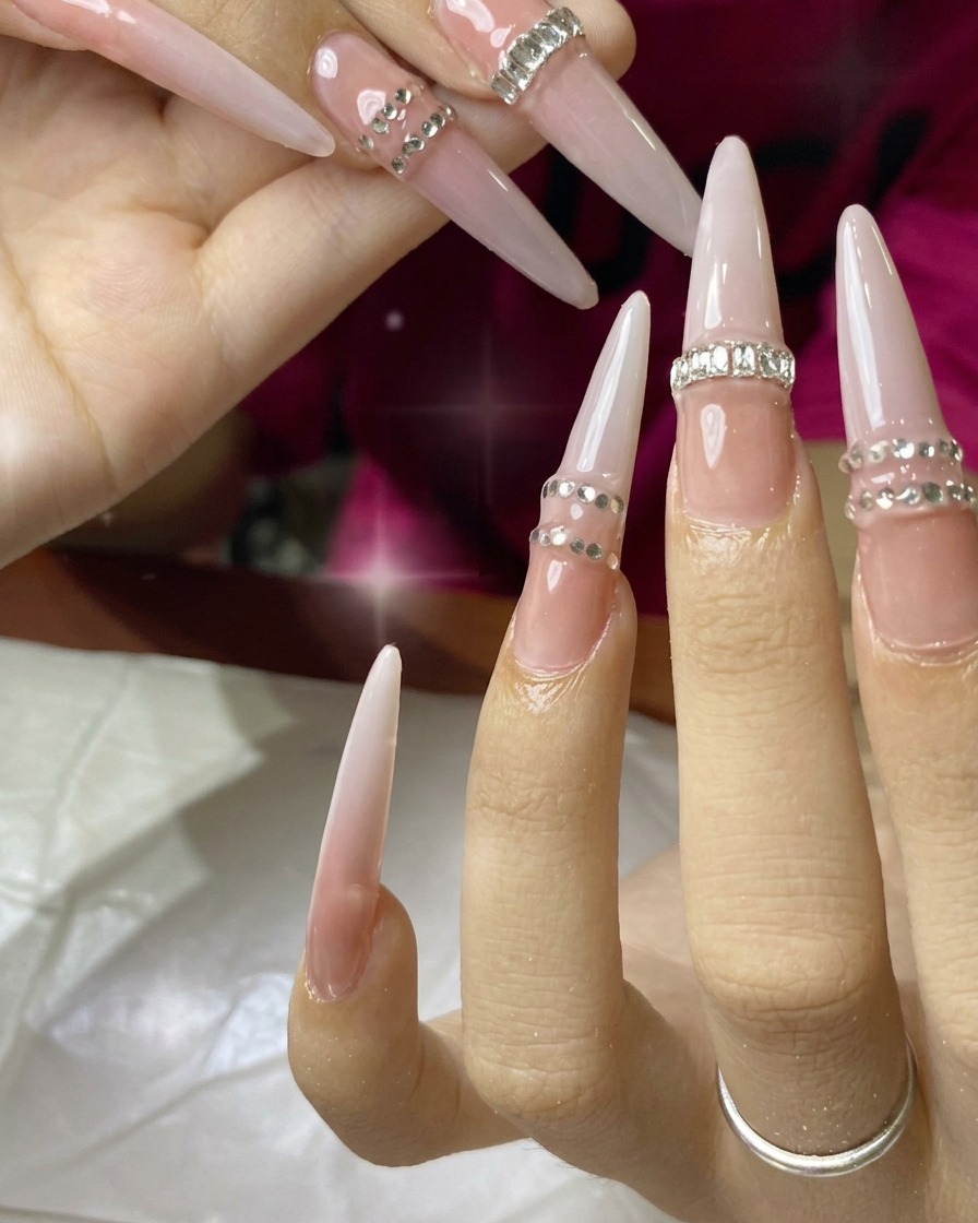 Un pinceau appliquant une couche de vernis semi-permanent nude sur une extension.