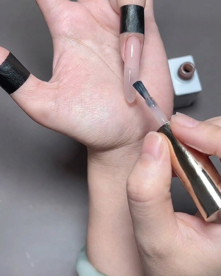 Un doigt avec du vernis gel fraîchement appliqué placé à lintérieur dune lampe à ongles pour la catalysation.