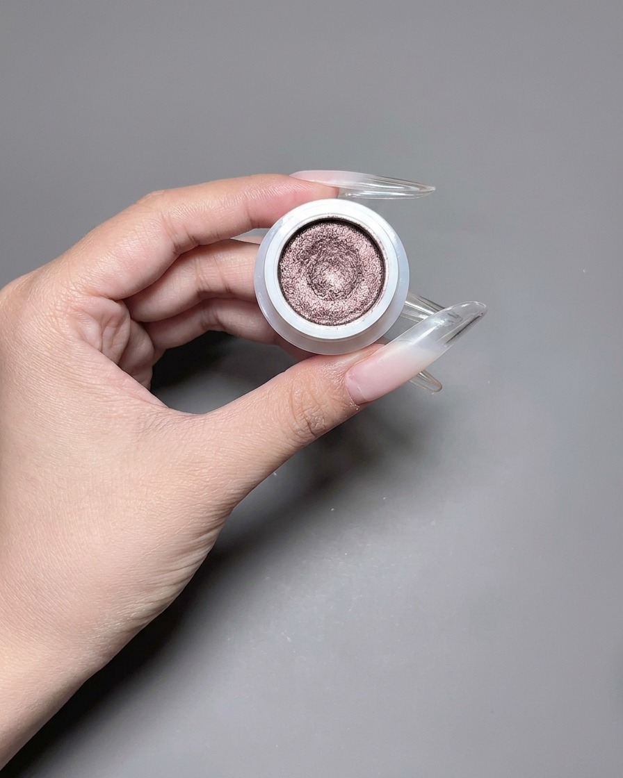 Un pinceau appliquant un vernis gel œil de chat chatoyant et réfléchissant sur un ongle long.