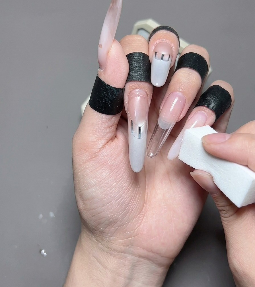 Une vue rapprochée dun pinceau liner peignant un bout de french blanc laiteux sur un ongle propre en forme damande.