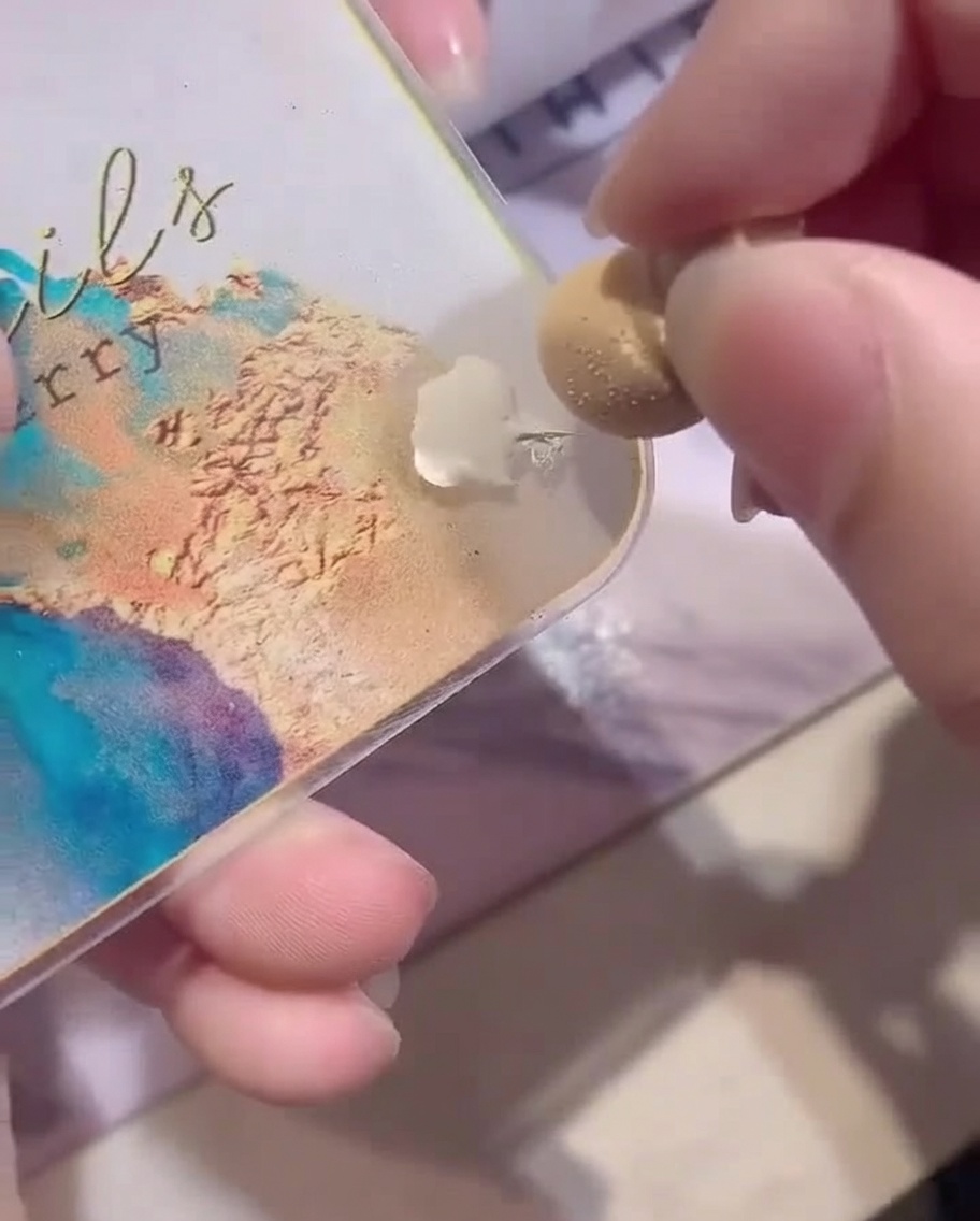 Gros plan montrant une éponge de maquillage blanche chargée de vernis gel blanc depuis une palette.