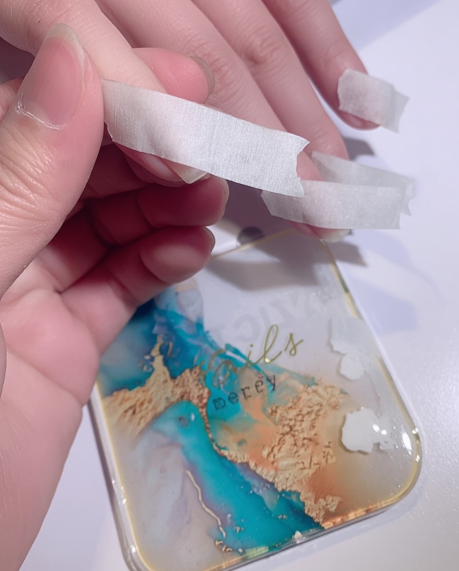 Une éponge tamponnant du vernis gel blanc sur la pointe dun ongle pour créer un effet ombré.