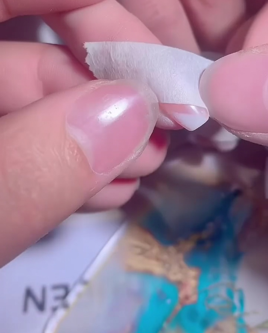 Un ongle avec un ombré de gel blanc partiellement appliqué étant préparé pour une seconde couche.
