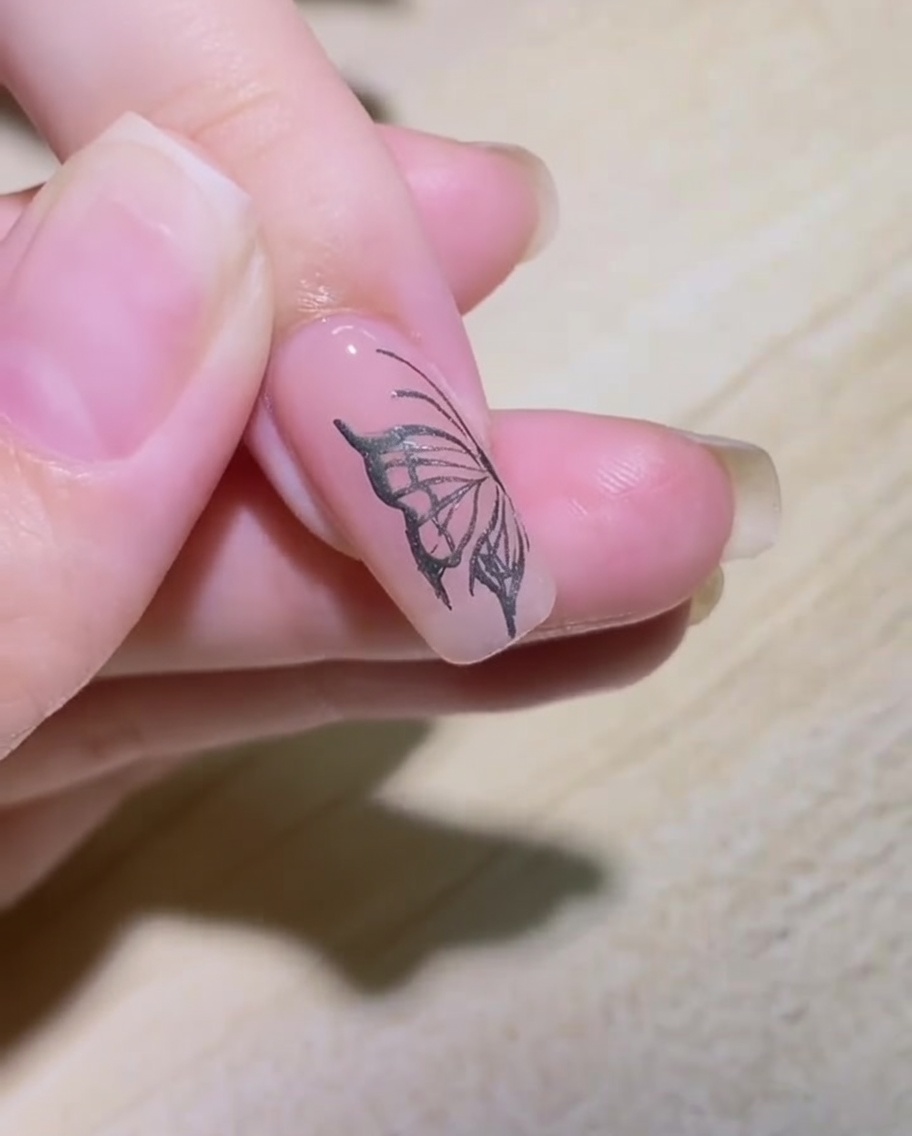 Vue rapprochée dun ongle dont le contour dune flamme est tracé au liner métallique.