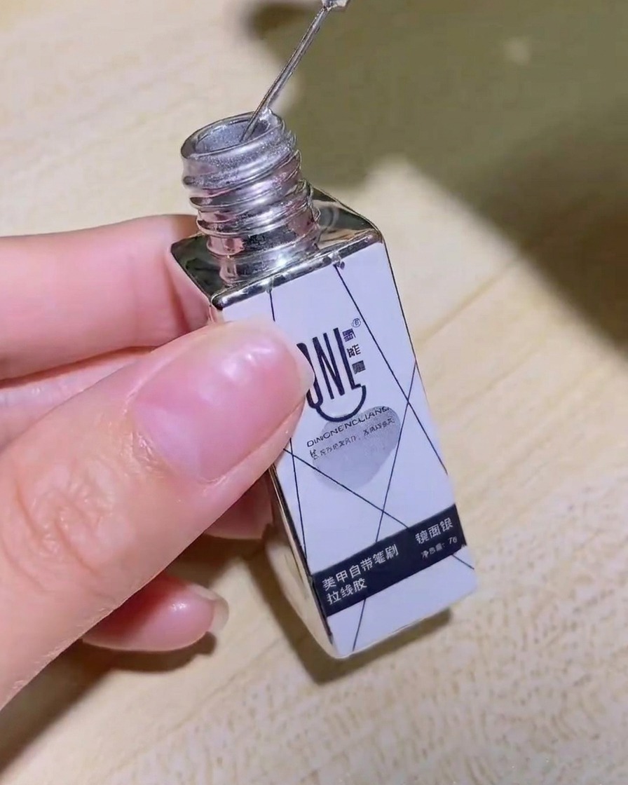 Une main tenant le flacon de gel liner miroir argenté, montrant clairement létiquette.