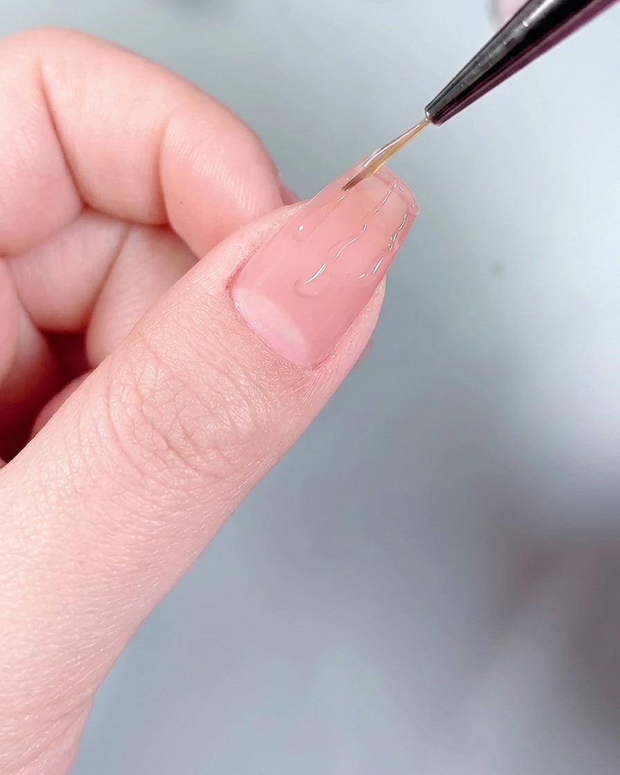 Un applicateur en silicone pressant de la poudre chrome argentée sur les lignes de colle en forme de flammes.