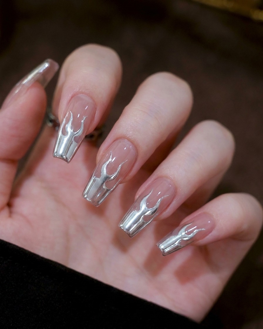 Gros plan montrant deux petits marquages en U symétriques en gel argenté au centre dun ongle.