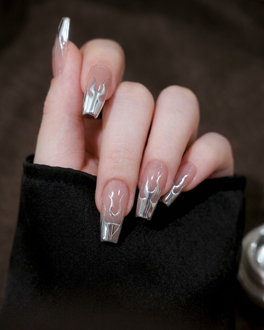 Gros plan dun ongle où les lignes de gel argenté sont reliées pour former une silhouette de flamme complète.