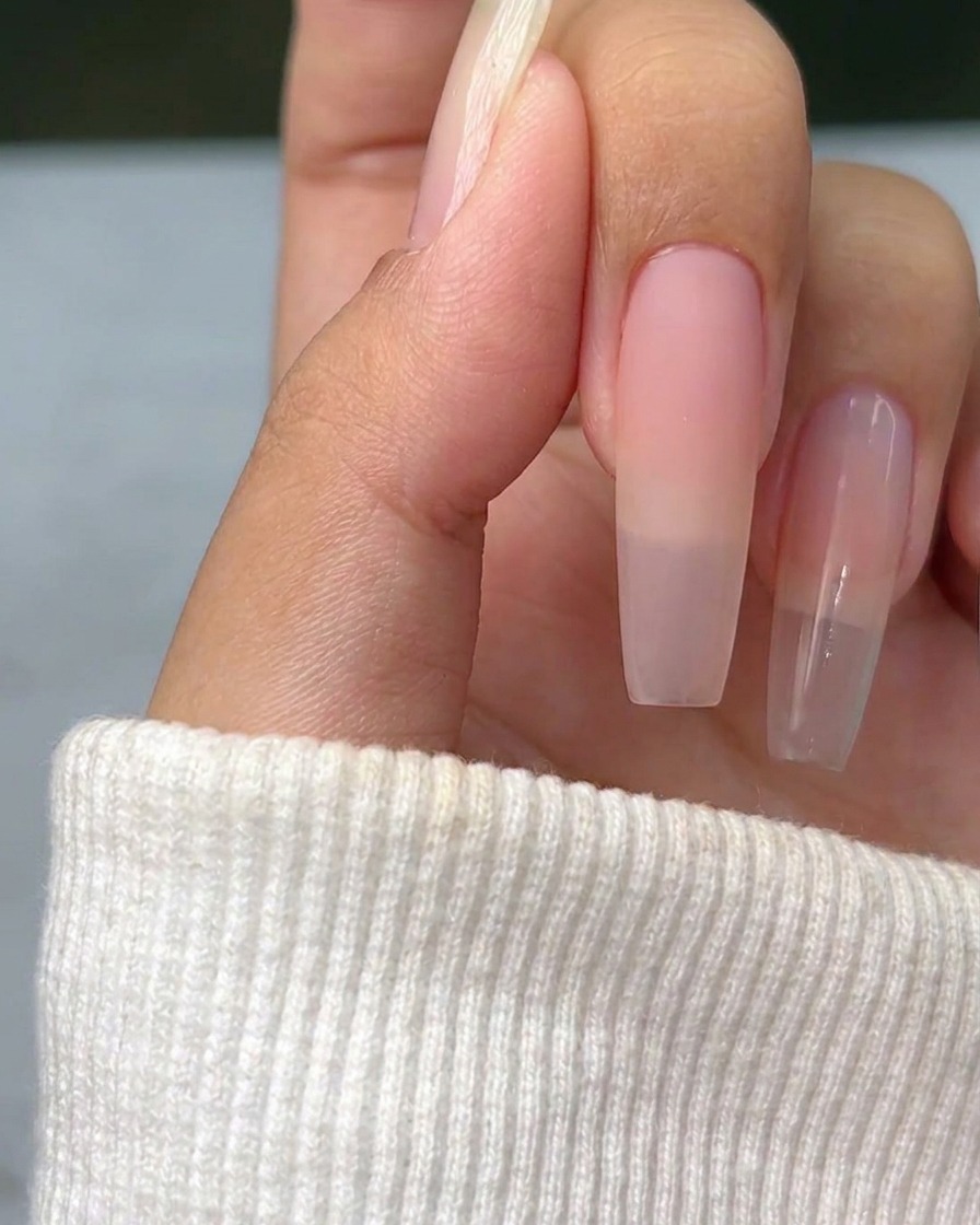 Une fine croix en argent métallique peinte sur la surface dun ongle naturel, servant de guide pour le nail art.