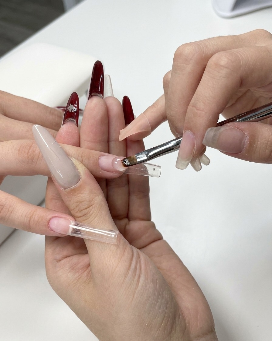 Un pinceau à gel déposant une perle de gel de construction transparent sur le chablon.